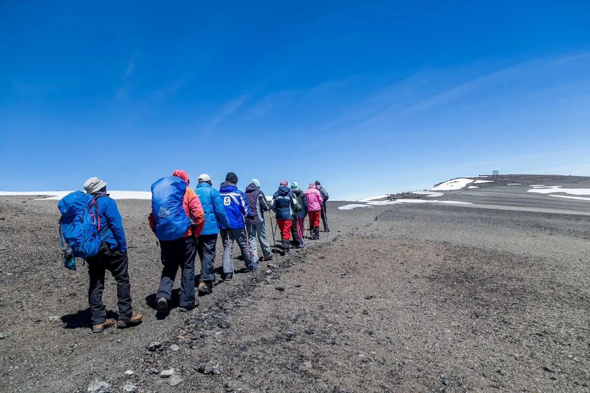 Gruppe von Wanderern, geführt vom Guide, im Gipfelbereich