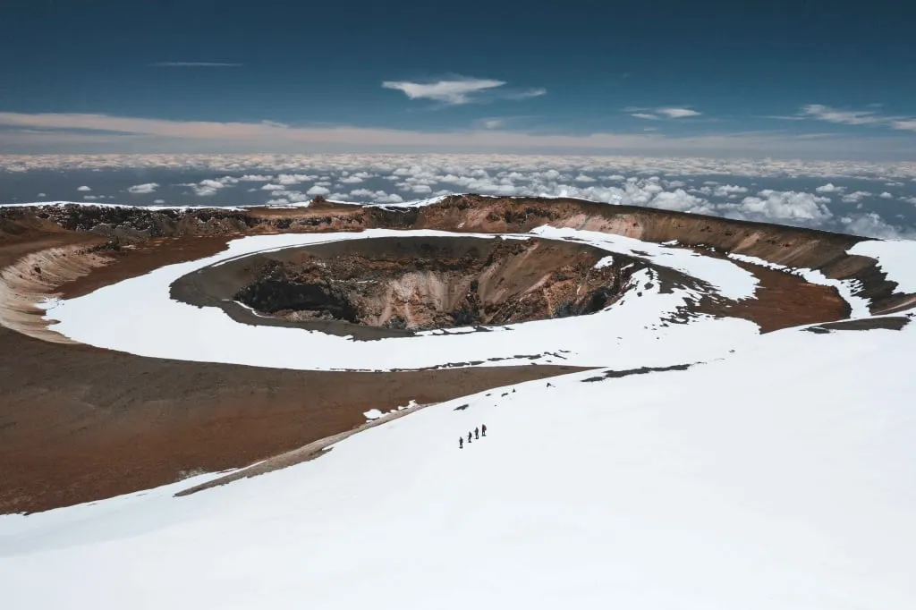 Der Krater des Mount Kibo auf dem Kilimandscharo erhebt sich 5.895 Meter über dem Meeresspiegel. Die Teilnehmer einer Altezza Travel-Expedition sind auf dem Schnee zu sehen.