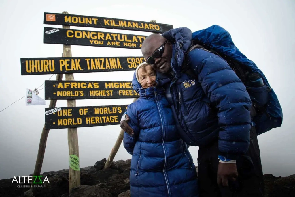 Angela Vorobeva and Elias Masawe on top of Mt Kilimanjaro at Uhuru Peak, 5895 meters