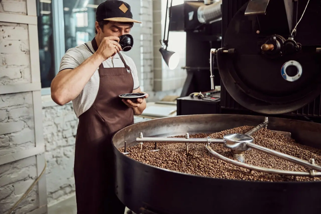 Дегустация кофе рядом с промышленным ростером — машиной для обжарки кофе