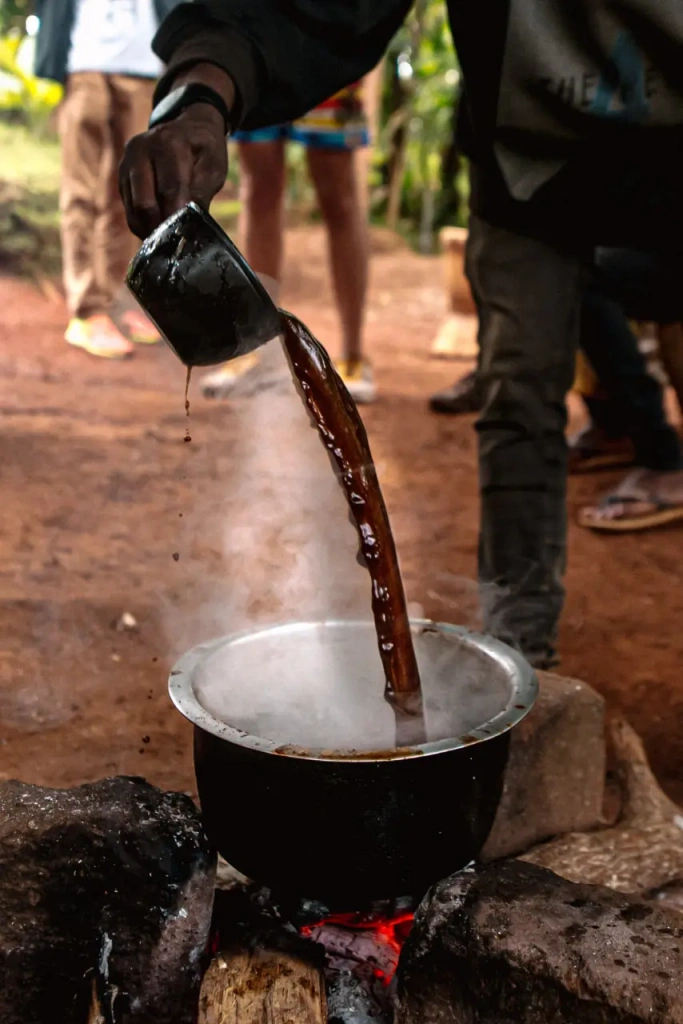 Pouring coffee during boiling. Kilimanjaro, Tanzania, 2023